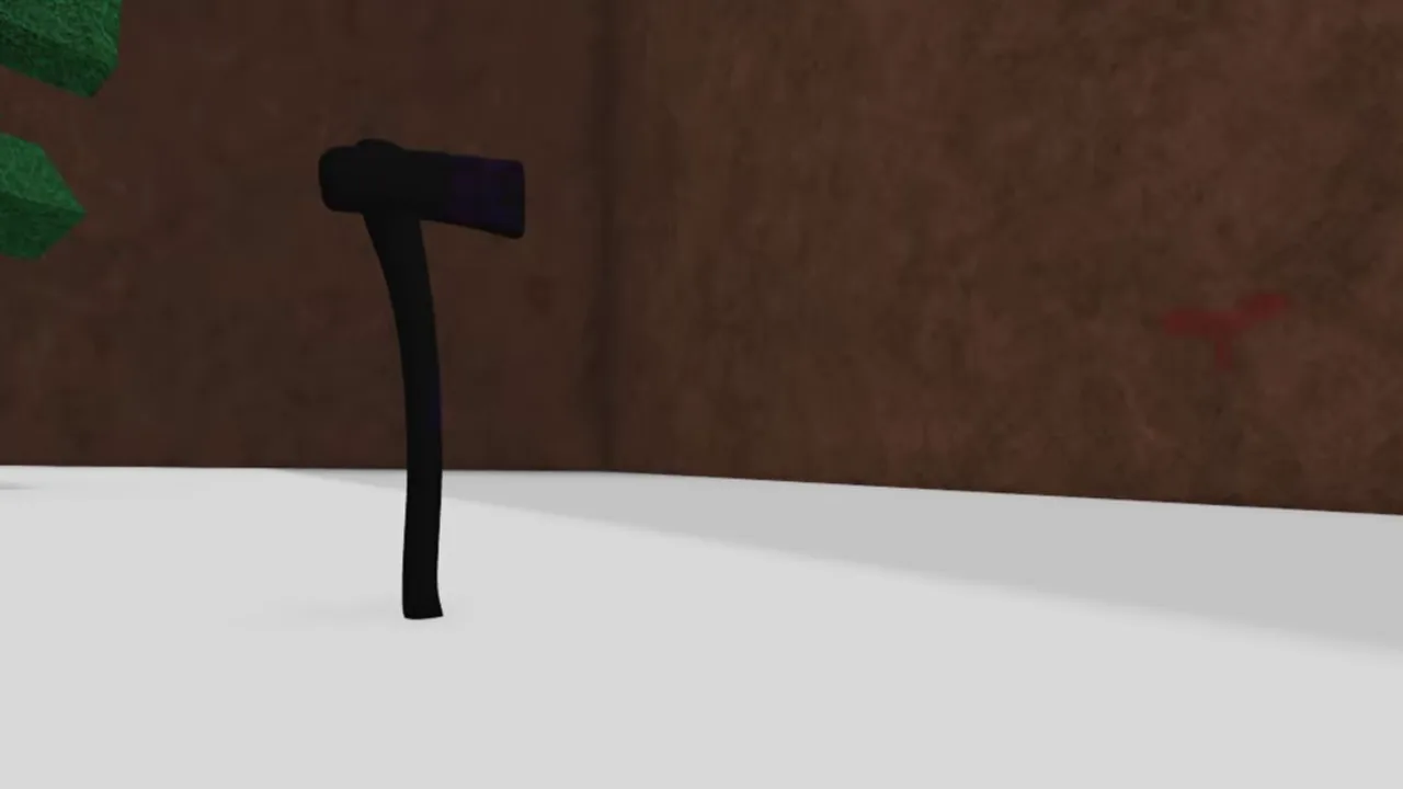 A pitch-black axe standing upright on snow in front of a rock wall